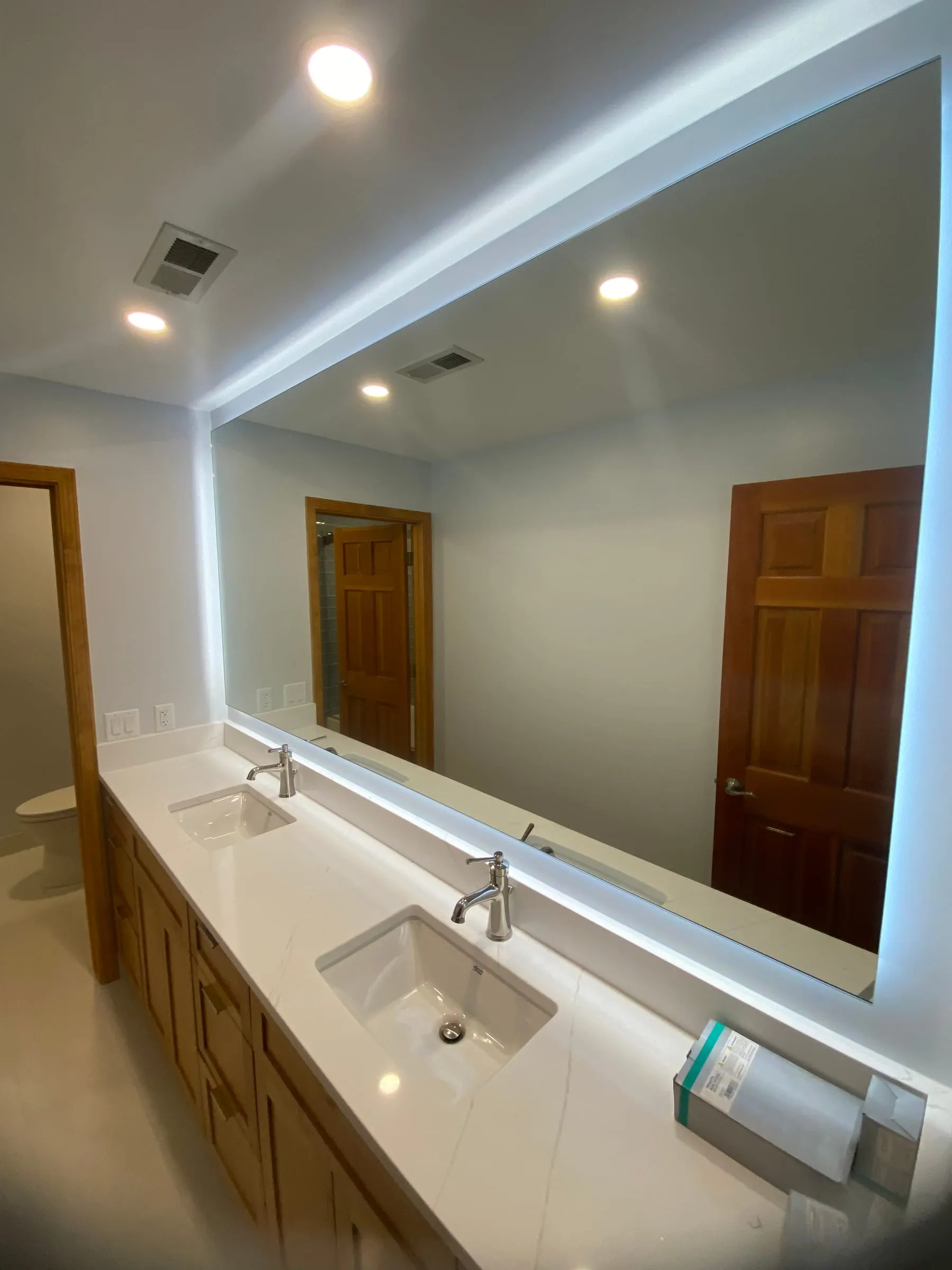 Large backlit LED mirror over a double bathroom vanity