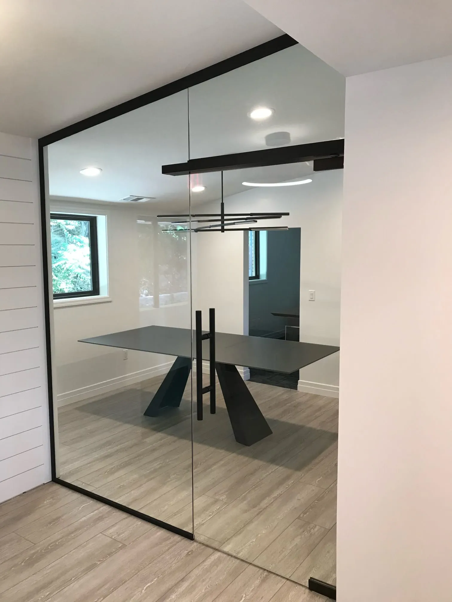 Black-frame glass wall around a dining area