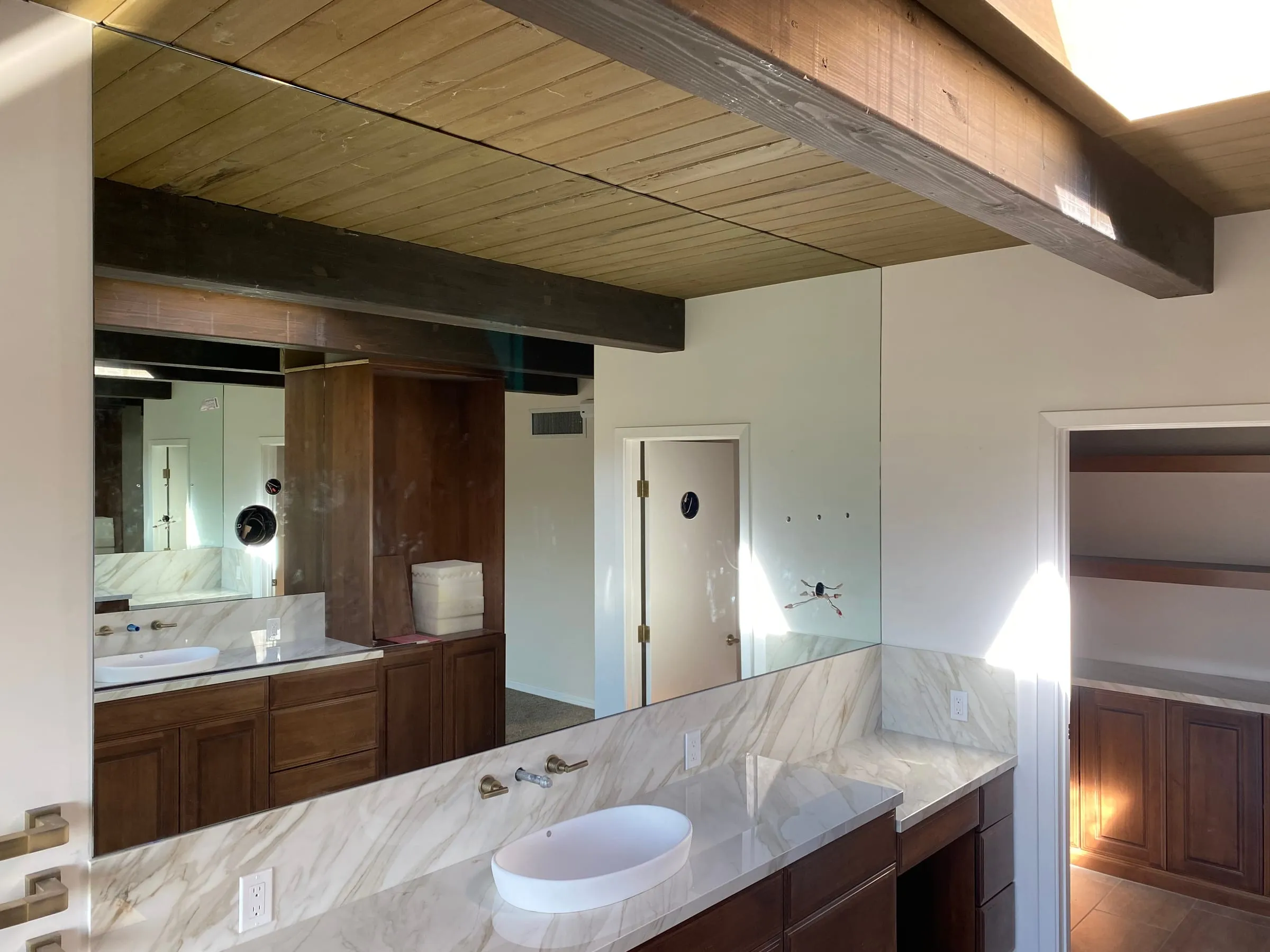 Custom vanity mirror in a bathroom with a wood ceiling