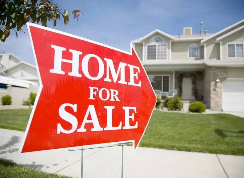 Home for sale sign in front of a house