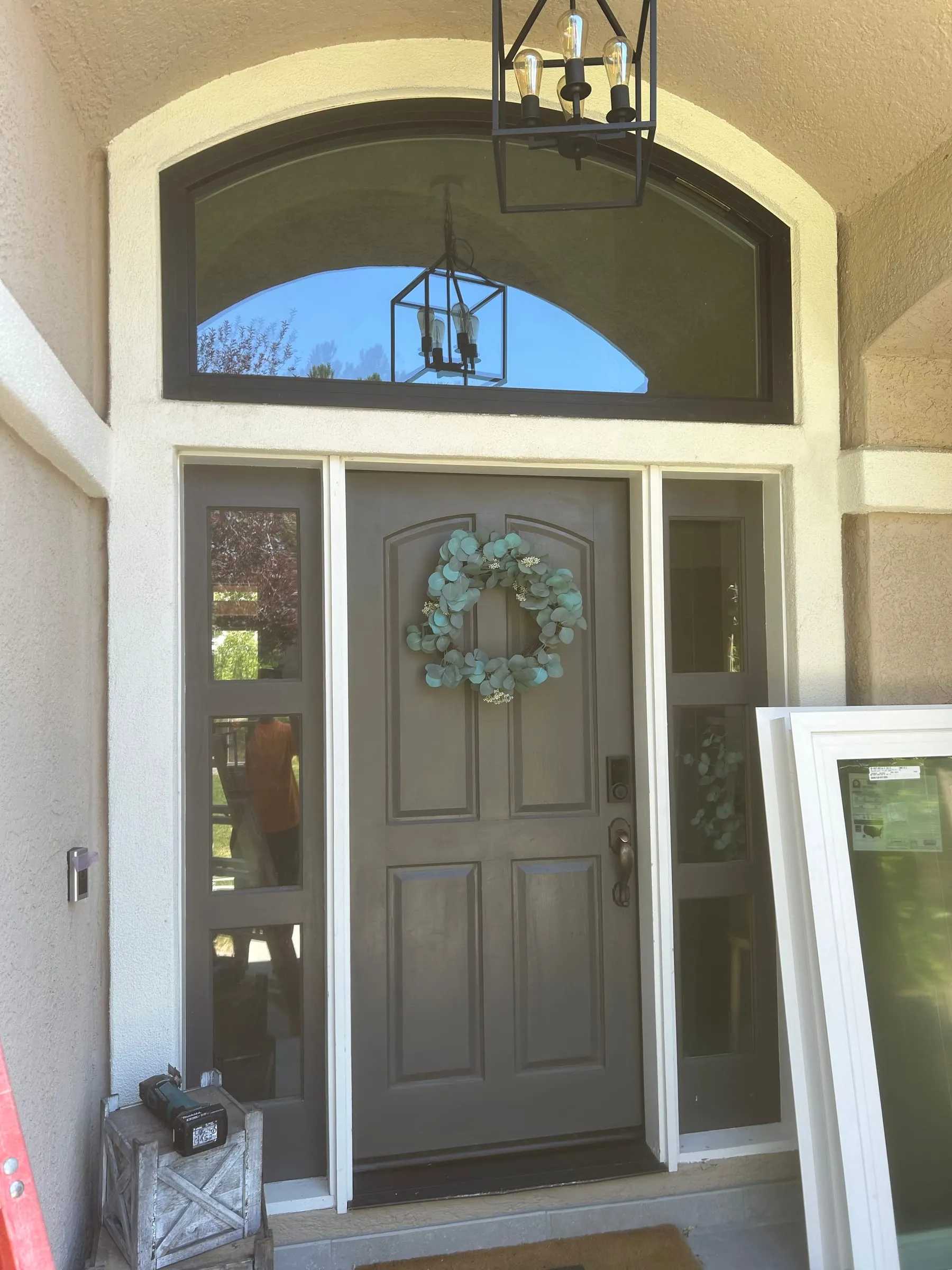 Arched transom window being installed above a front door